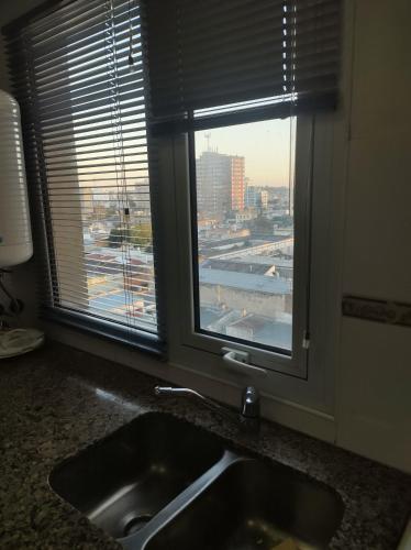 fregadero de cocina con ventana con vistas a la ciudad en MI DEPTO en Tandil