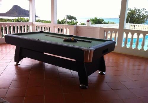 a pool table on a balcony with a view of the ocean at La villa chez Ingrid in Antsiakambony