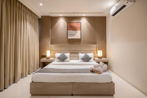 a bedroom with a large bed and two night stands at The Lodgers Luxury Hotel Near Golf Course Road Gurgaon in Gurgaon