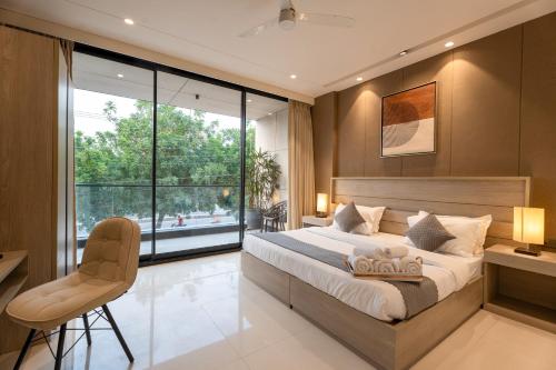 a bedroom with a large bed and a large window at The Lodgers Luxury Hotel Near Golf Course Road Gurgaon in Gurgaon