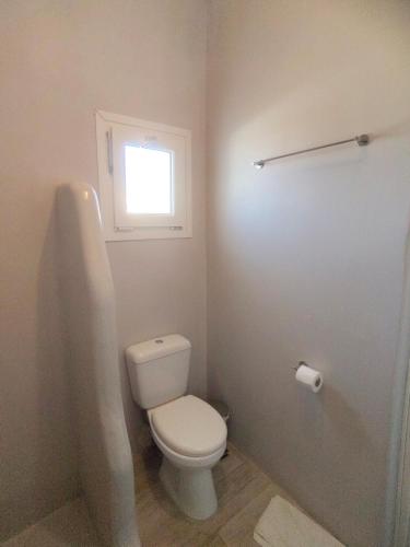 a bathroom with a toilet and a window at Ftelia Breeze in Klouvas
