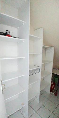 Cette chambre comprend un placard blanc avec des étagères blanches. dans l'établissement Studio AXEL entre plage et port de plaisance, à La Rochelle
