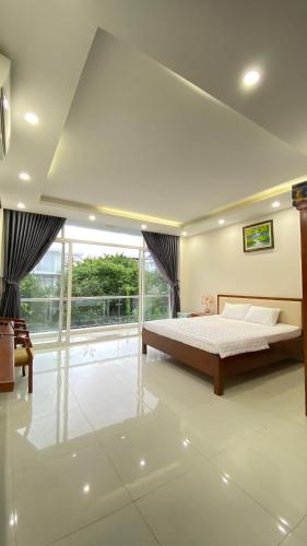 a bedroom with a bed and a large window at Villa Sao Biển SB14 FLC Sầm Sơn in Sầm Sơn