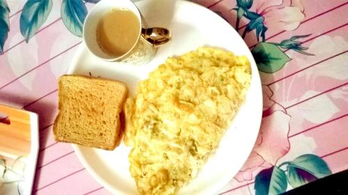 カリンポンにあるHotel Orchidの卵、トースト、コーヒーが入った皿