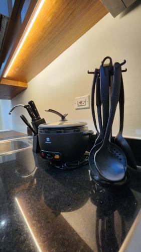 a stove with a pot and a pan on a counter at Kakurega Manila in Manila