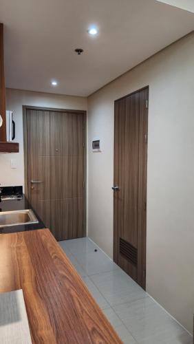 a kitchen with wooden cabinets and a counter top at Kakurega Manila in Manila