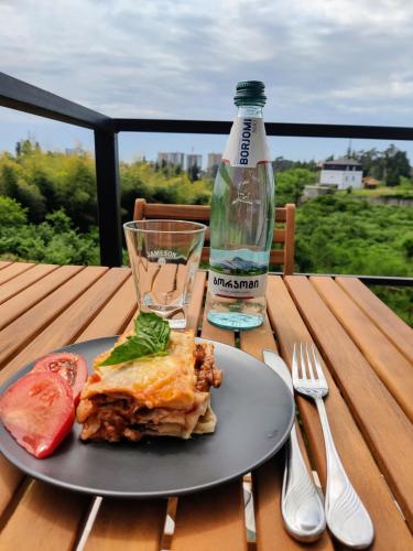 a plate of food on a table with a bottle of water at Apartments in Chakvi in Chakvi