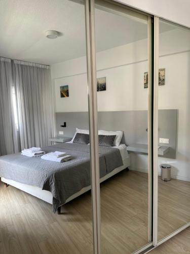 een slaapkamer met een bed en een grote spiegel bij Fantastic Apartment 163 in Finikoudes in Larnaka