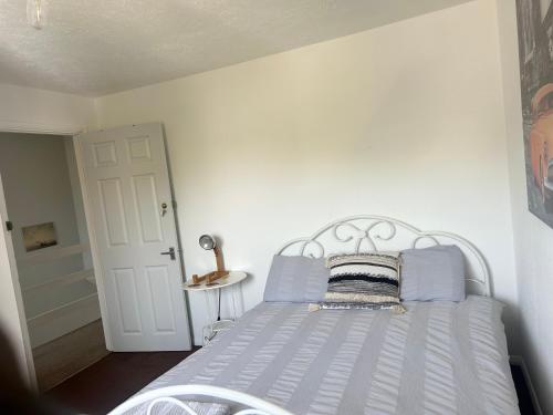 a white bed with blue pillows in a bedroom at The Heath Retreat in Whitstable