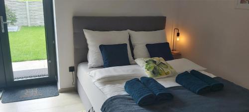a bedroom with a bed with blue pillows on it at Ambasada zieleni in Uniejow