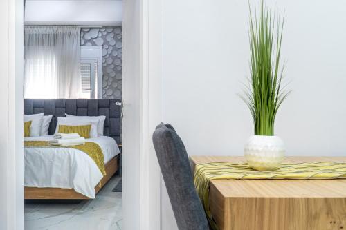 een slaapkamer met een bed en een tafel met een potplant bij King Davids Suite Athens finest! in Athene