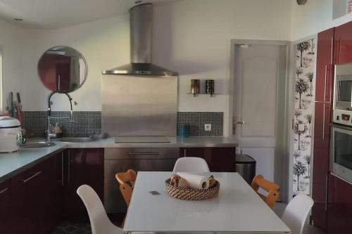 une cuisine avec une table et un panier dans l'établissement Mon jardin secret, à Lunel