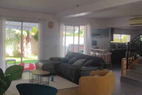 - un salon avec un canapé et des chaises dans l'établissement Mon jardin secret, à Lunel