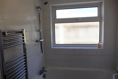 uma casa de banho com uma janela e uma banheira em Cosy Cottage to Relax or Explore em Mistley