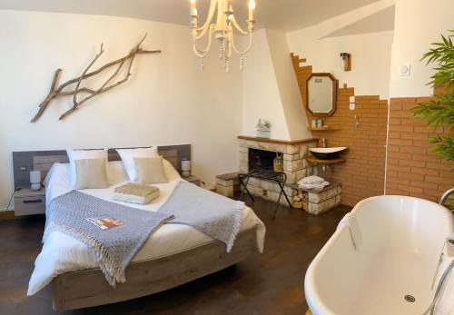 a bedroom with a bed and a bath tub and a chandelier at La Bulle dans le Palmier in Toulouse