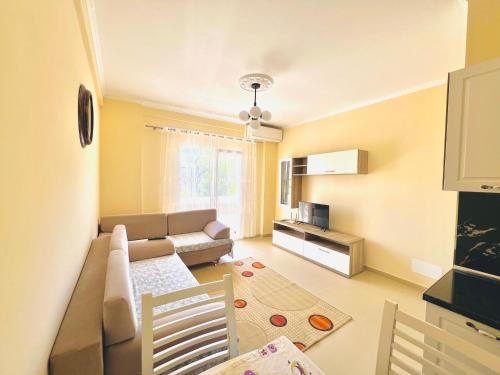 ein Wohnzimmer mit einem Sofa und einem Tisch in der Unterkunft N&E Apartment in Durres in Durrës