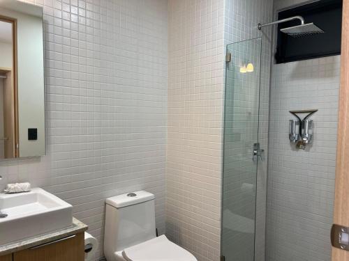 a bathroom with a toilet and a glass shower at New Cozy Apartment with Terrace, Pool and Gym in Guadalajara