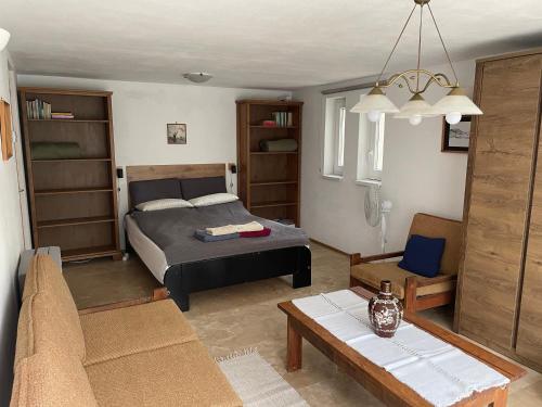 ein Schlafzimmer mit einem Bett und ein Wohnzimmer in der Unterkunft Studió Apartmanok in Balatonfüred