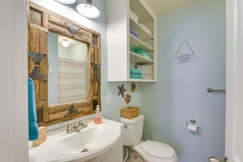 a bathroom with a toilet and a sink and a mirror at Walk to Shore Surfside Beach Home with Bay Views in Surfside Beach