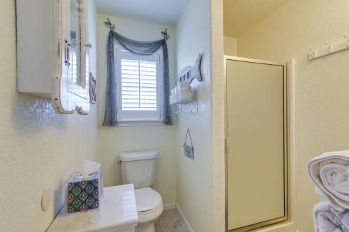 a bathroom with a toilet and a window at Walk to Shore Surfside Beach Home with Bay Views in Surfside Beach