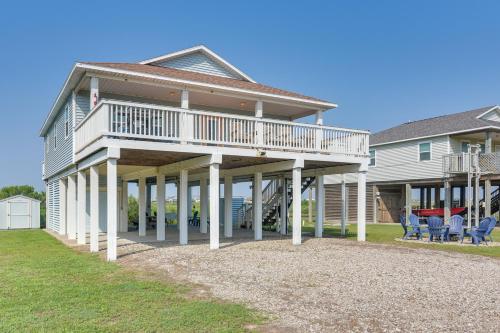 a large house with a deck and chairs on the lawn at Walk to Shore Surfside Beach Home with Bay Views in Surfside Beach