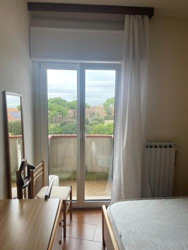 a room with a bed and a window with a view at AMPIO BILOCALE Caorle LUNGOMARE LEVANTE in Caorle