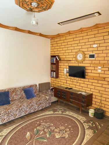 a living room with a couch and a flat screen tv at Cozy Private Apartment in Asyut