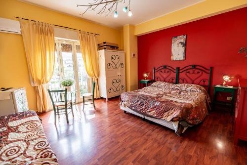 una camera da letto con pareti rosse, un letto e un tavolo di Domus Musia a Milazzo