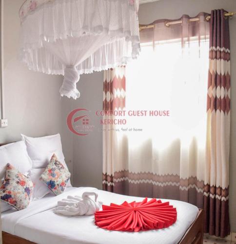 a bedroom with a white bed with a window at Heritage Villa Hotel & Accomodation in Kericho