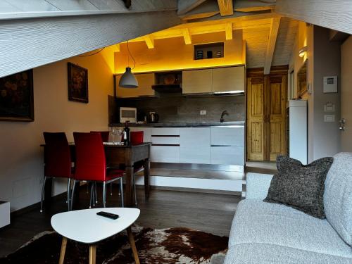 sala de estar y cocina con sofá y mesa en Maison Tatà en Aosta