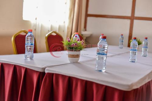 a table with bottles of water and flowers on it at Heritage Villa Hotel & Accomodation in Kericho