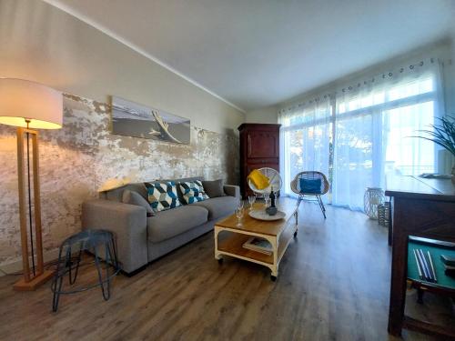 un salon avec un canapé et une table dans l'établissement Royan - MAISON des années 50 RENOVEE à proximité de la PLAGE de FONCILLON, à Royan