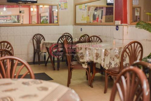 a dining room with a table and chairs in a restaurant at Heritage Villa Hotel & Accomodation in Kericho