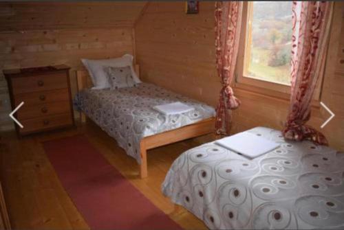 Cottage Dolovi في نيكشيتش: غرفة نوم بسريرين ونافذة