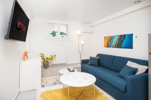 un salon avec un canapé bleu et une table dans l'établissement Le Valrose Cocon Urbain au cœur de Nice Souplex, à Nice