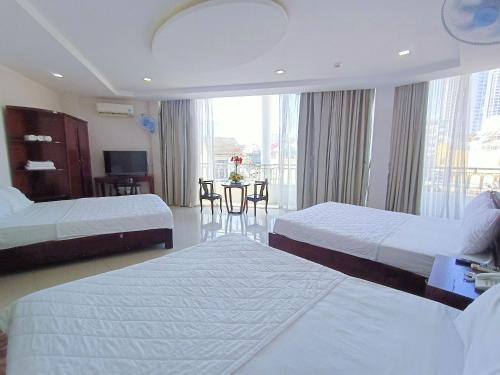 芽莊的住宿－Mangolia Hotel，酒店客房设有两张床和一张桌子。