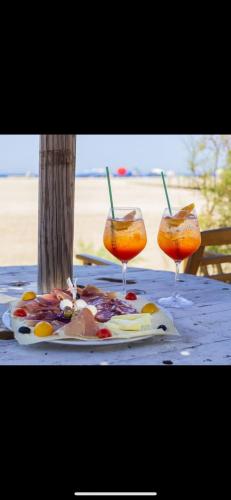 a plate of food on a table with two glasses at Borgo Ingurtosu in Ingurtosu