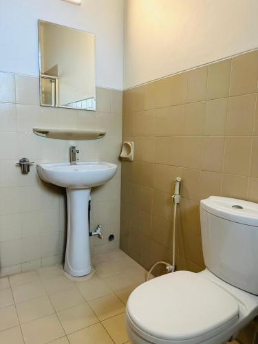 a bathroom with a white toilet and a sink at Viveka Serviced Apartments in Nugegoda
