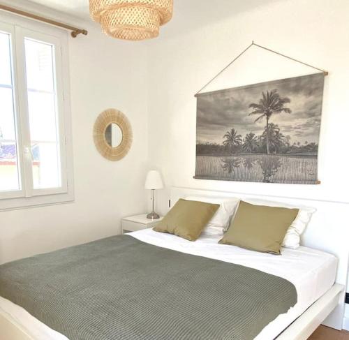 une chambre avec un lit avec un tableau sur le mur dans l'établissement Les Oliviers T2 Ajaccio centre, à Ajaccio
