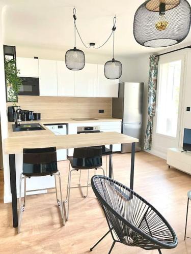 une cuisine avec une table et des chaises dans une pièce dans l'établissement Les Oliviers T2 Ajaccio centre, à Ajaccio