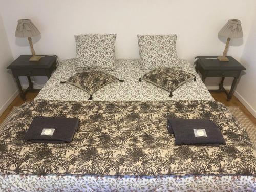 - une chambre avec un lit avec deux oreillers et deux tables dans l'établissement Gîte l’aroma, à Faleyras