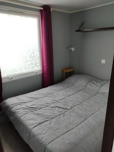 um quarto com uma cama grande e uma janela em Camping du phare d opale p48 em Le Portel
