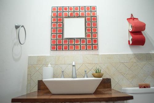 a bathroom with a sink and a mirror on the wall at Loma Puskana - Hostería in Cachí