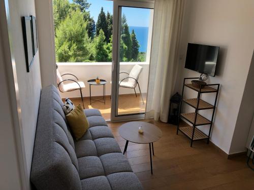 Sala de estar con sofá gris y TV en Apartments Lungo Mare Ulcinj, en Ulcinj