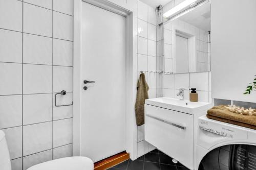 uma casa de banho branca com um lavatório e um espelho em Beautiful apartment at Frogner Oslo em Oslo