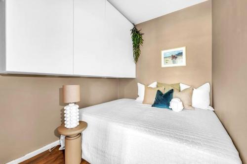 um quarto com uma cama com lençóis brancos e almofadas azuis em Beautiful apartment at Frogner Oslo em Oslo