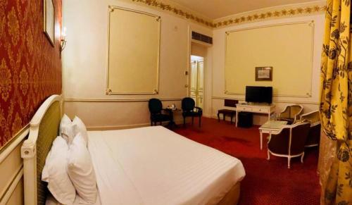Pokój hotelowy z łóżkiem i biurkiem w obiekcie Windsor Palace Luxury Heritage Hotel Since 1906 by Paradise Inn Group w Aleksandrii