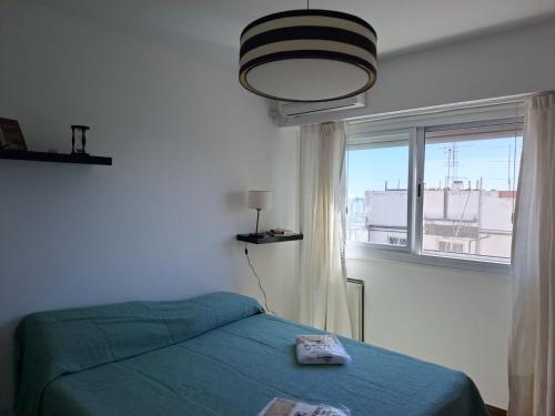 une chambre avec un lit vert et une fenêtre dans l'établissement Cómodo apartamento frente Quinta Presidencial, à Florida