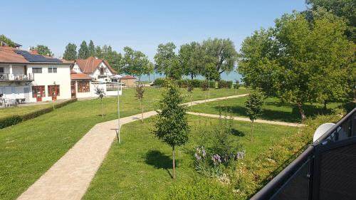 a view of a garden with trees and a pathway at Wellapartman Zamárdi in Zamárdi