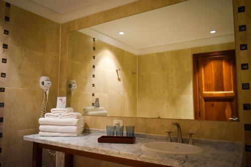 y baño con lavabo y espejo. en Hotel Casino Catamarca en San Fernando del Valle de Catamarca